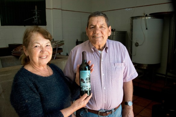 Don Trino con su mujer, que muestra orgullosa el vino premiado en el concurso local. Imprescindible probar la ropa vieja de Margarita. / LUIS ROCA ARENCIBIA